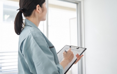 住宅点検を行うスタッフの後ろ姿。