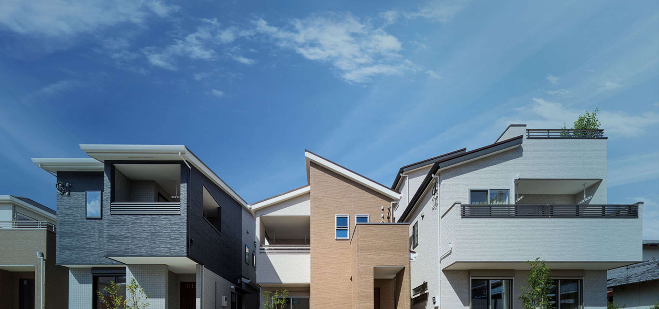 青空の下に建ち並ぶモダンなデザインの戸建住宅