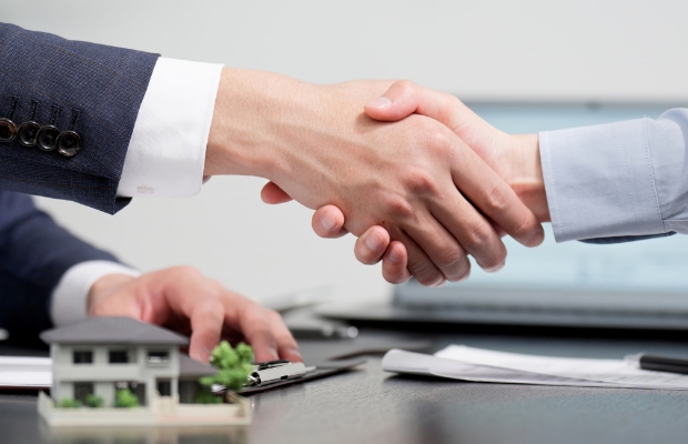 土地売却の契約成立を象徴する握手の様子