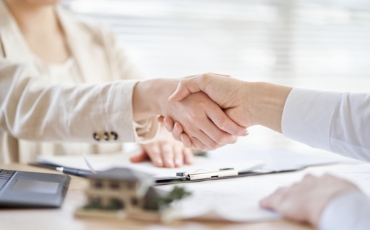 土地売却の契約成立を象徴する握手